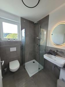 a bathroom with a shower and a toilet and a sink at Egge Resort 7d Viaduktblick, Balkon in Altenbeken