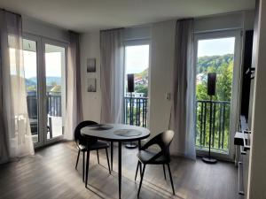 comedor con mesa, sillas y ventanas en Egge Resort 7g Viaduktblick, Balkon en Altenbeken