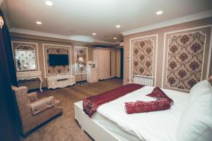 een slaapkamer met een bed en een stoel erin bij Baku Hotel Ganja in Ganja