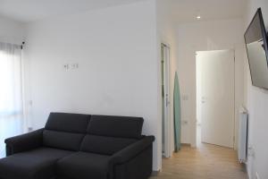 sala de estar con sofá negro y espejo en Olbia Apartment, en Olbia