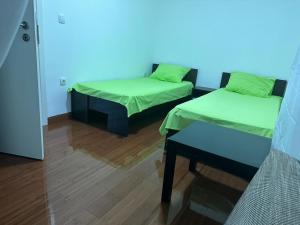 een kamer met twee bedden en een tafel erin bij Apartman Aurora in Veliko Gradište