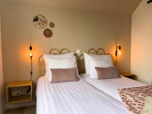 a bedroom with a bed with white sheets and two pillows at Bij het bos Texel in De Koog