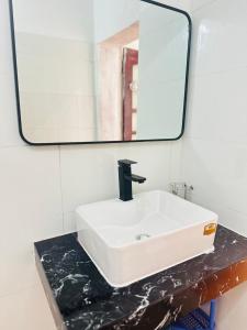 a bathroom sink with a mirror on a counter at Huong Thao Hostel & Tours in Dien Bien Phu
