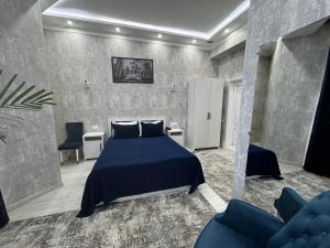 a bedroom with a blue bed and two chairs at BEX SUENO HOTEL in Samarkand