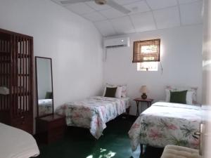 um quarto com duas camas e um espelho em The Grove em Maharagama