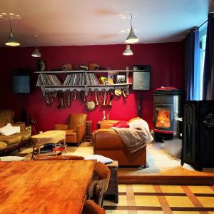 a living room with red walls and a fireplace at Le Jolis Bois in Raon-lʼÉtape