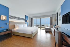 a hotel room with a bed and a flat screen tv at D Varee Jomtien Beach, Pattaya in Jomtien Beach