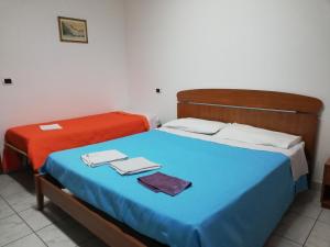 twee bedden naast elkaar in een kamer bij AFFITTACAMERE GELINDO in Silvi Marina