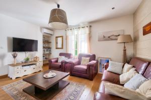 sala de estar con sofá, sillas y TV en Adresse privilegiee a Ars-en-Re, en Ars-en-Ré