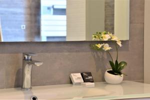 a bathroom sink with a vase with flowers in it at Magnificent accommodation , 200m from the beach. in Labenne +52 photos
