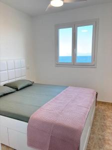 um quarto com uma cama e duas janelas em Casa Mirtilla em Playa del Burrero