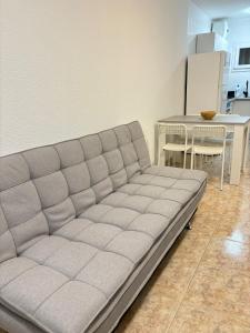 um sofá numa sala de estar com uma mesa e uma cozinha em Casa Mirtilla em Playa del Burrero