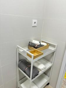 a bathroom with a shelf with towels on it at Casa Mirtilla in Playa del Burrero
