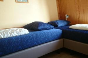 two blue pillows sitting on a bed in a room at Heggerank 80* in Nieuwvliet