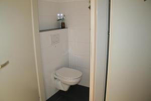 a bathroom with a white toilet in a room at Heggerank 80* in Nieuwvliet