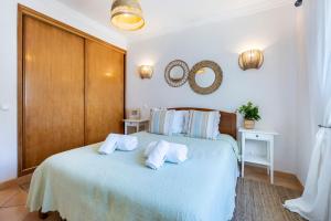 Un dormitorio con una cama con almohadas blancas. en Villa som das Ondas, en Budens