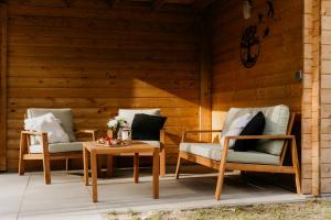 twee stoelen en een tafel op een patio bij Romantisch Wellness Boshuisje met Sauna & Hottub in Meijel