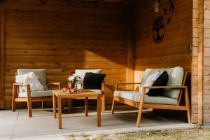 two chairs and a table on a patio at Romantisch Wellness Boshuisje met Sauna & Hottub in Meijel