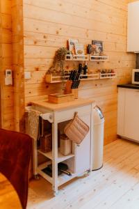 a kitchen with a table in a wooden wall at Romantisch Wellness Boshuisje met Sauna & Hottub in Meijel +36 photos