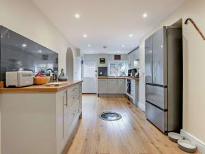 uma cozinha com electrodomésticos em aço inoxidável e pisos em madeira em 3 Bed in Broughton 94143 em Broughton