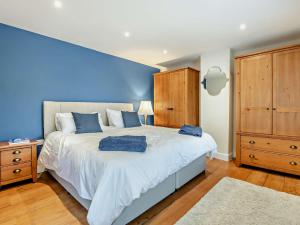 um quarto com uma cama grande e uma parede azul em 3 Bed in Broughton 94143 em Broughton