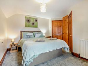 a bedroom with a large bed and a wooden door at 3 Bed in Wolsingham 94198 in Wolsingham