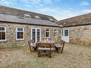 a table and chairs in front of a stone building at 3 Bed in Wolsingham 94198 in Wolsingham