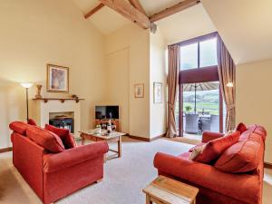 a living room with two red chairs and a window at 3 Bed in Malham 94260 in Airton