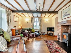 a living room with leather furniture and a fireplace at 3 Bed in Lower Rochford 94240 in Newnham
