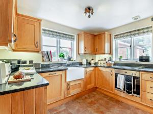 a kitchen with wooden cabinets and black counter tops at 3 Bed in Lower Rochford 94240 in Newnham