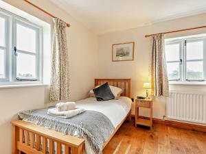 a bedroom with a bed and two windows at 3 Bed in Lower Rochford 94240 in Newnham