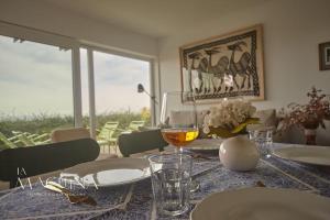 - une table à manger avec un verre de vin dans l'établissement Las Flores del Mar, a un paso de Comillas, à Comillas