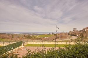 une vue sur un chemin de terre avec une clôture dans l'établissement Las Flores del Mar, a un paso de Comillas, à Comillas