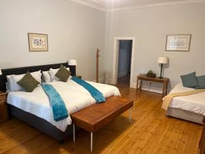 a bedroom with two beds and a wooden floor at Beyond Cui Bono in Sunland