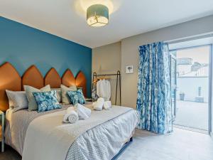 a bedroom with a large bed with blue walls and a window at 4 Bed in Newquay 90069 in Newquay