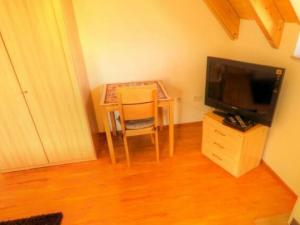 einen kleinen Tisch mit einem Stuhl und einem TV in der Unterkunft Gästehaus Ritter in Sinsheim