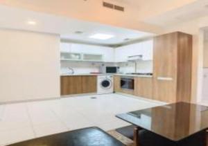 a large kitchen with a table and a microwave at Key View - Glamz Residence Tower 2 in Dubai