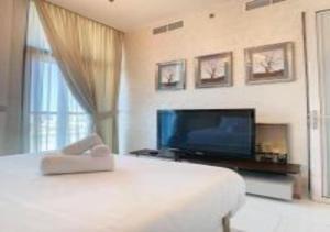 a bedroom with a large bed and a flat screen tv at Key View - Glamz Residence Tower 2 in Dubai