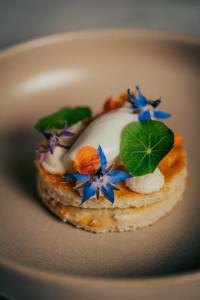 a pastry with flowers on top of it on a plate at Sporthotel am Semmering in Semmering