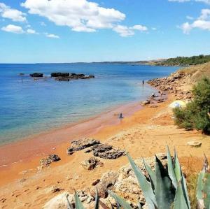 a sandy beach with rocks and the ocean at Agri B&B Terre Joniche in Isola Capo Rizzuto