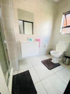 a bathroom with a tub and a toilet and a sink at The Blyde Crystal Lagoon Cologne4 in Pretoria