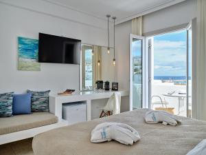 a bedroom with a bed and a view of the ocean at Kanale's Rooms & Suites in Naousa