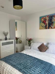 a bedroom with a large bed with a blue blanket at Home from Home in Brompton