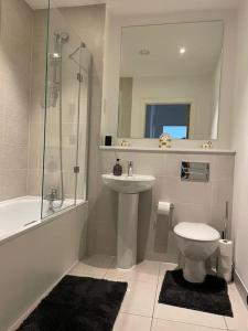 a bathroom with a sink and a toilet and a shower at Home from Home in Brompton