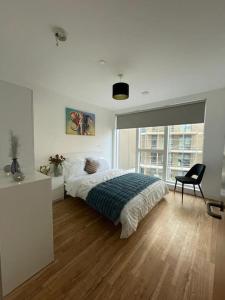 a bedroom with a bed and a chair and a window at Home from Home in Brompton