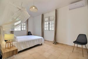 勒弗朗索瓦的住宿－Villa Flamboyant，卧室配有白色的床和椅子