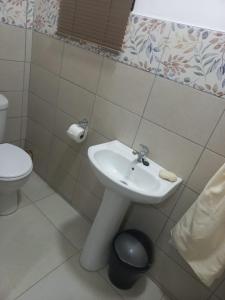 uma casa de banho com um lavatório e um WC em First Class Lodge em Benoni