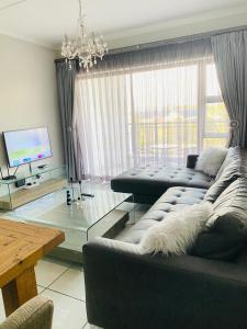 a living room with a couch and a glass table at The Blyde Crystal Lagoon Cologne4 in Pretoria