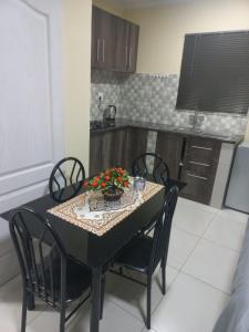 First Class Lodge في بينوني: مطبخ مع طاولة وكراسي عليها زهور