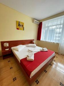 海王星市的住宿－Hotel Callatis，一间卧室配有一张带红色毯子的大床